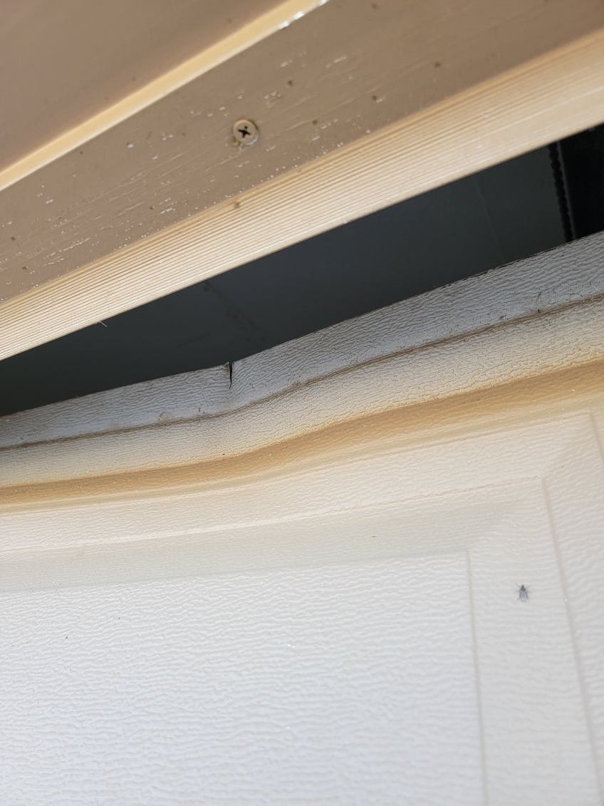 Close-up of a residential garage door panel and upper clearance area