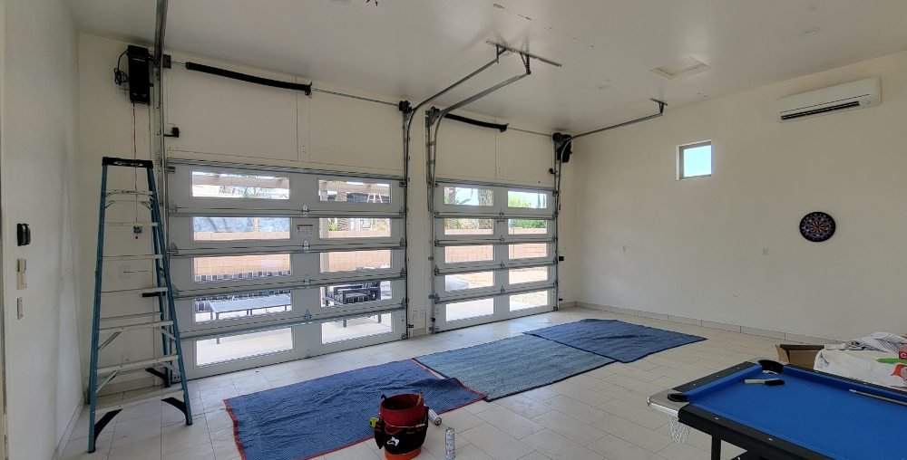 Modern glass-panel residential garage doors in a finished interior space
